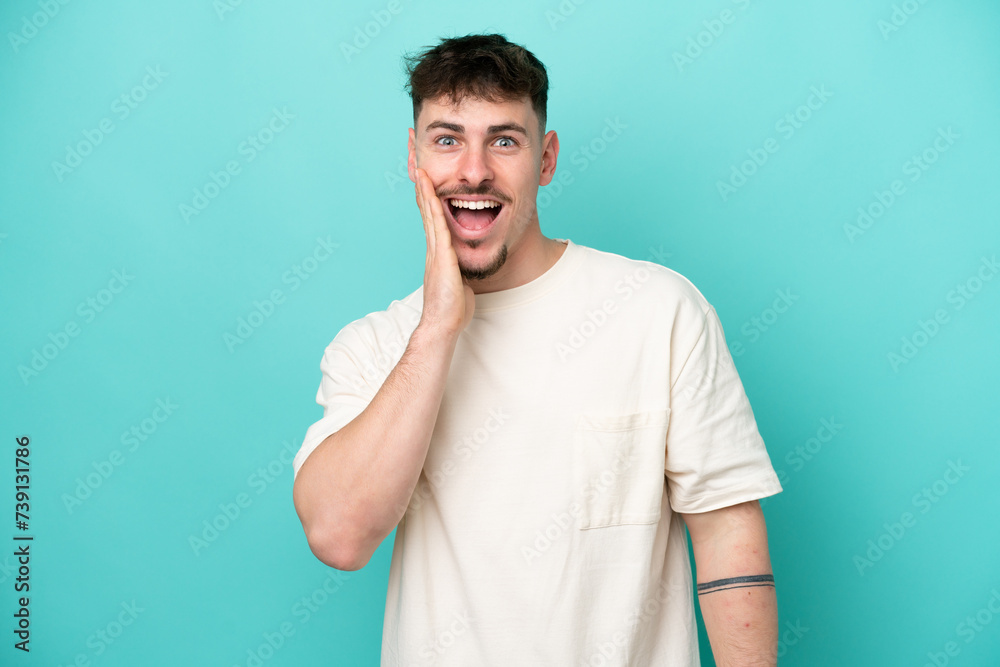 Young caucasian handsome man isolated on blue background with surprise and shocked facial expression