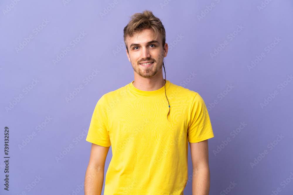 Fototapeta premium Young handsome blonde man isolated on purple background laughing
