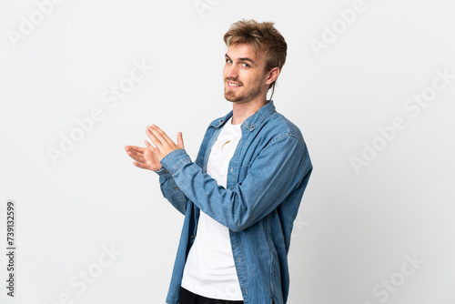 Young handsome man isolated on white background applauding