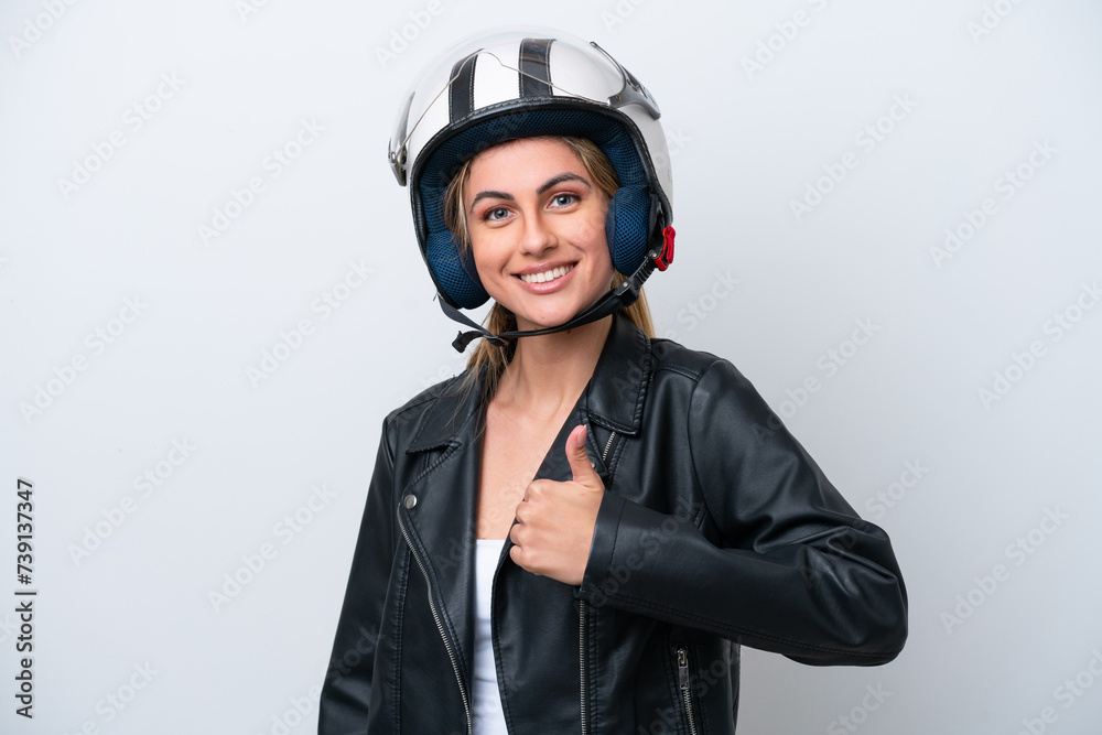 Young caucasian woman with a motorcycle helmet isolated on white background giving a thumbs up gesture Young caucasian woman with a motorcycle helmet isolated on white background giving a thumbs up gesture