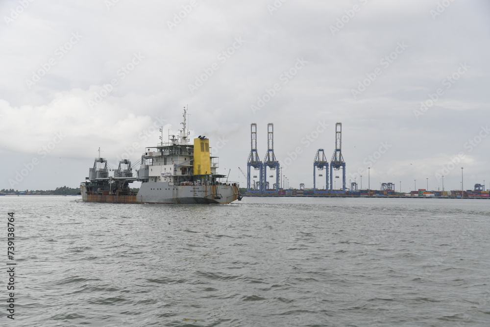 Kochi, India - September 2nd 2023: Cochin Port view from backwater. Logistics and transportation activities. Large container cargo ship moving in the ocean near Kochi , India's coastal Kerala state.