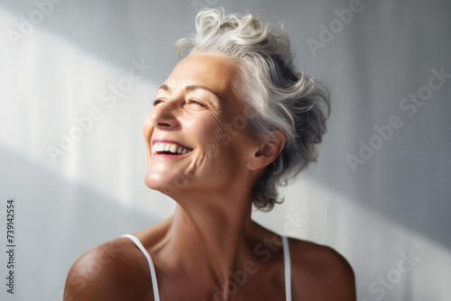Joyful mature woman relishing sunlight in serene setting. Positivity and wellness.