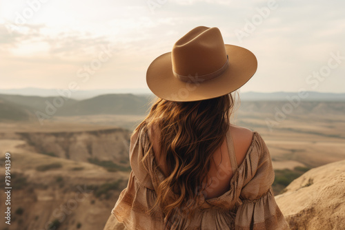 Woman in hat enjoying scenic landscape view. Travel and adventure.
