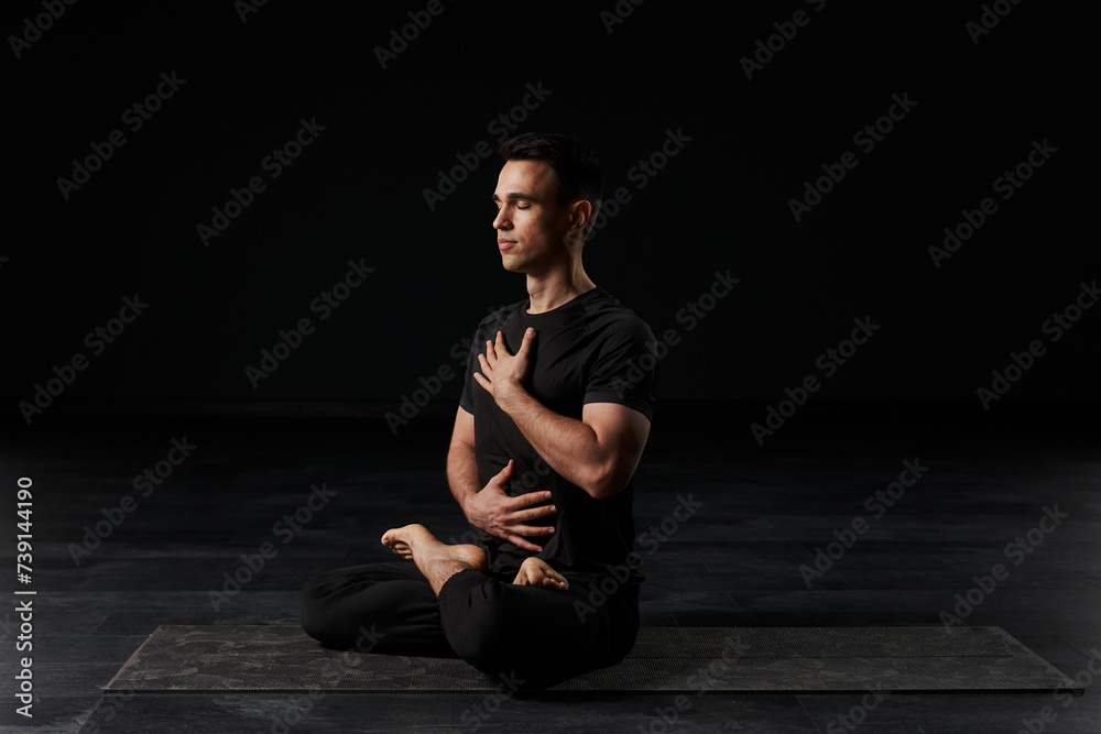 With poise and grace, a striking young man in black attire immerses himself in the meditative practice of yoga, sculpting his body into mesmerizing postures. With poise and grace, a striking young man in black attire immerses himself in the meditative practice of yoga, sculpting his body into mesmerizing postures.
