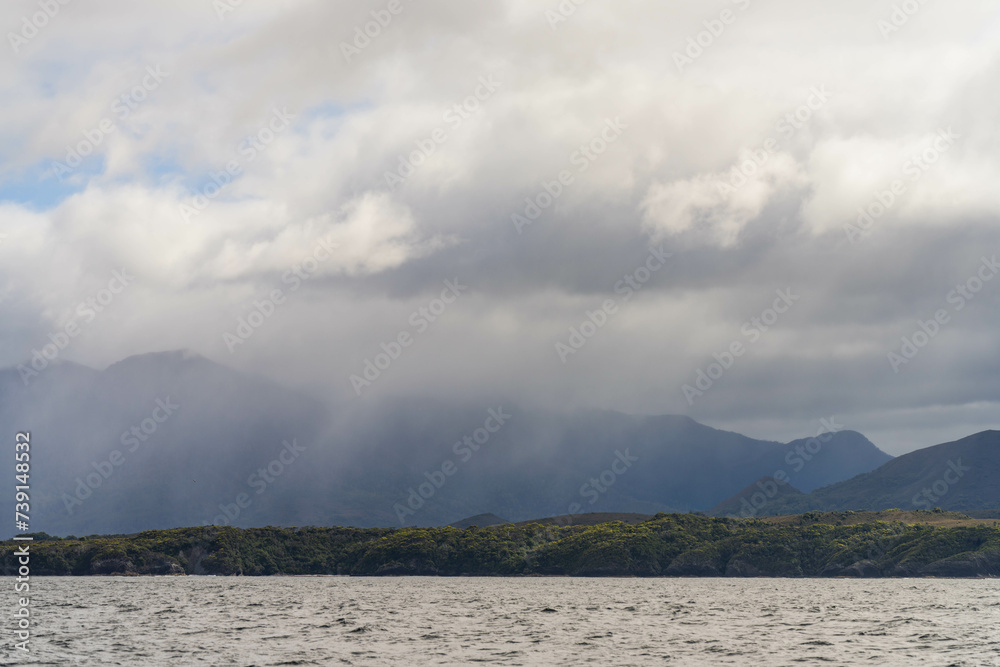 Yacht sailing on the horizon near the beach on the ocean ina remote beautiful landscape, Tasmania, Australia and new zealand Yacht sailing on the horizon near the beach on the ocean ina remote beautiful landscape, Tasmania, Australia and new zealand