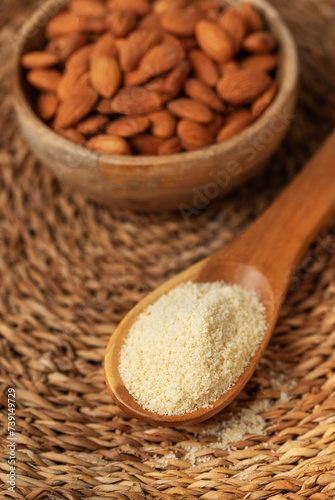 Fresh almond flour in a  wooden spoon and almonds