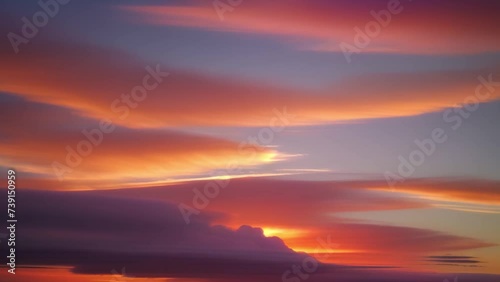 A time lapse captures nature's canvas as vibrant sunset clouds streak across the sky in a breathtaking display of color.
