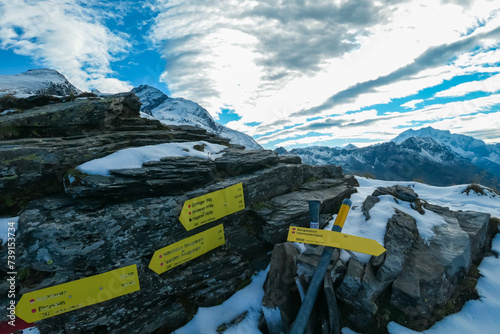 Information signs near alpine cottage Hannoverhaus in High Tauern National Park, Carinthia, Austria. Idyllic snow covered hiking trail with panoramic view of mountain peaks Hochalmspitze and ANkogel photo