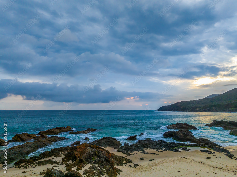 Rain clouds, rocks and sunrise at the seaside Rain clouds, rocks and sunrise at the seaside