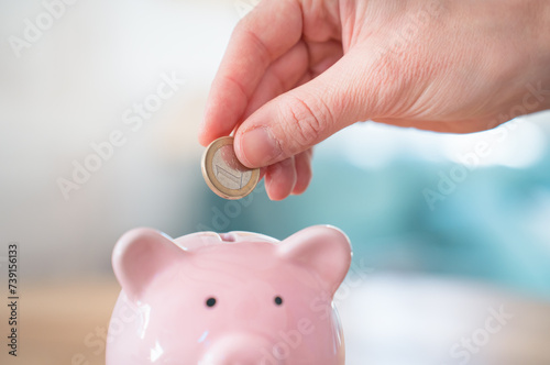 Save money household expenses. Hands puts coin in piggy bank. Power pricing energy crisis