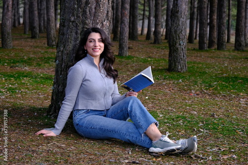 a woman lying on a tree and reading a book
