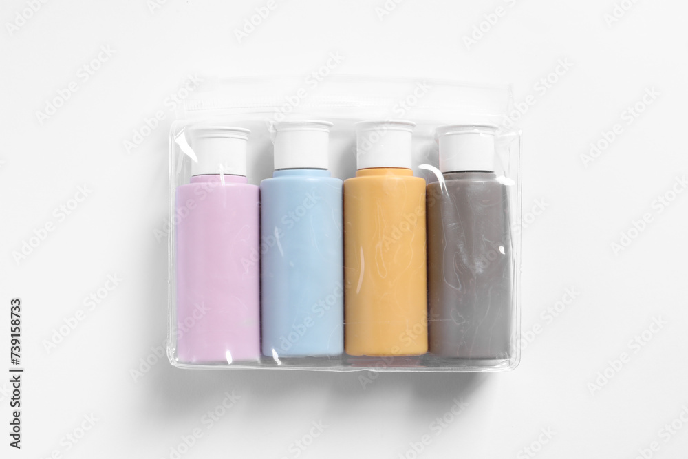 Cosmetic travel kit in plastic bag on white background, top view Cosmetic travel kit in plastic bag on white background, top view
