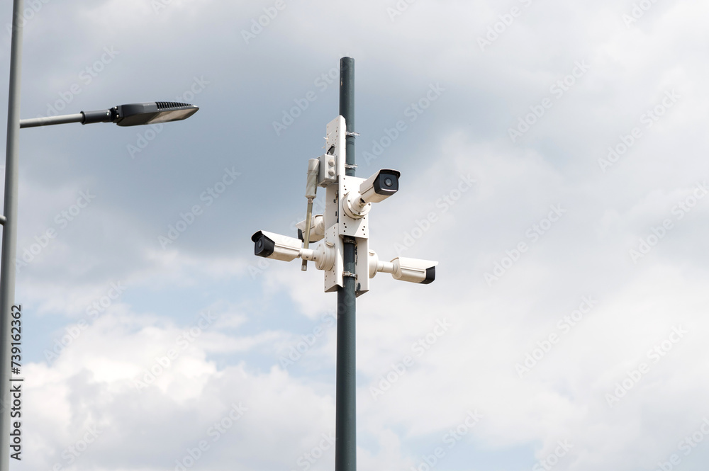 Urban Surveillance Cameras Against Cloudy Sky