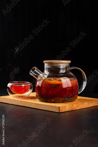 Fruit tea in a transparent teapot and glass