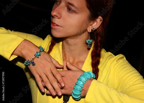 Selfie portrait of a red-haired girl in light blue jewelry made of natural howlite stone.