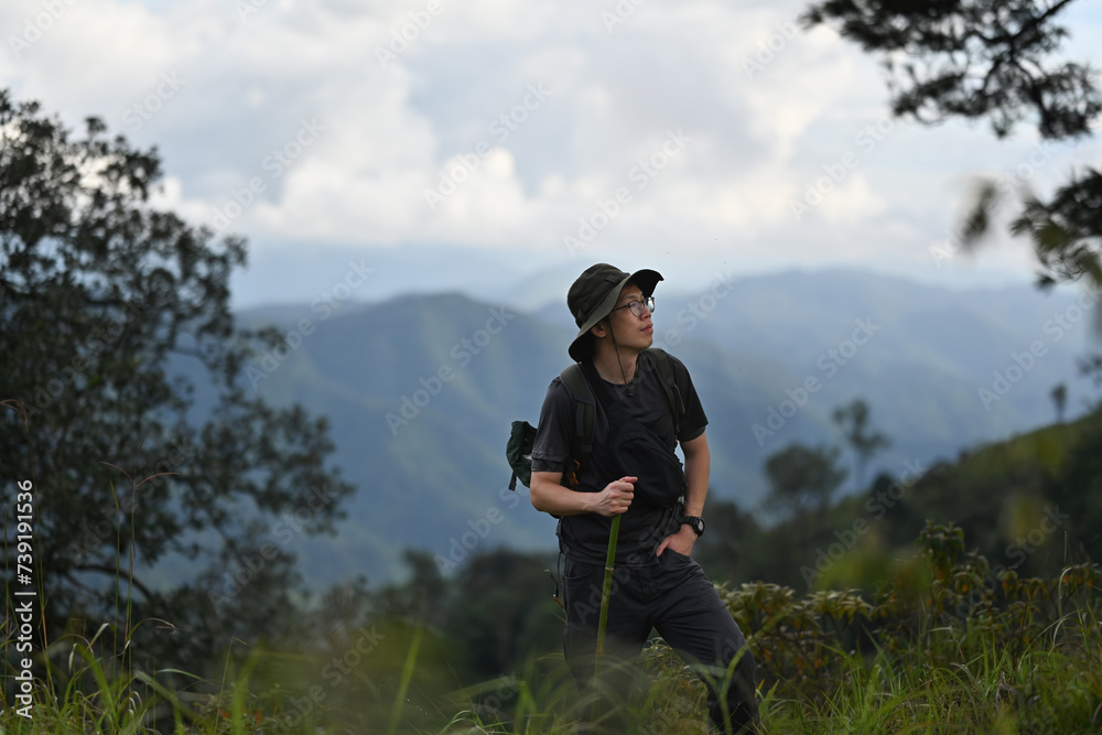 Portrait with Asian adventurer man hiking with a backpack on top of the mountain, A Solo travel concept Portrait with Asian adventurer man hiking with a backpack on top of the mountain, A Solo travel concept