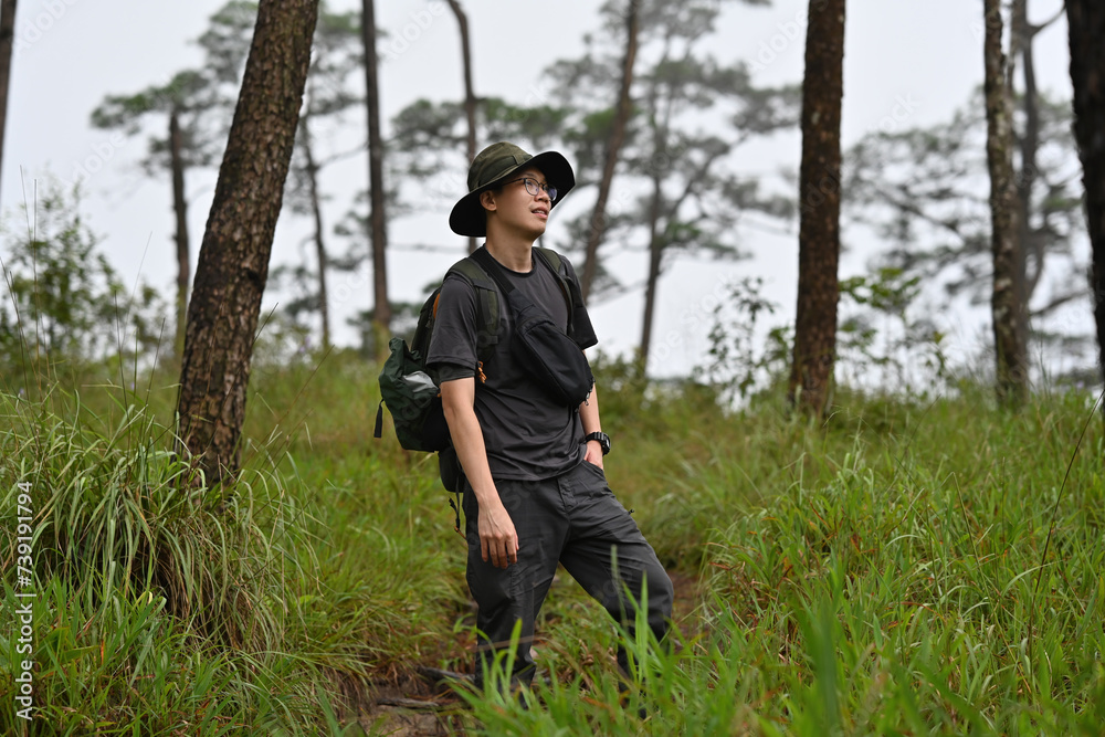 Asian male hiker with a backpack explore the forest, Solo travel concept Asian male hiker with a backpack explore the forest, Solo travel concept