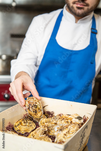 chef prepara ostra cruda ennrestaurante gourmet de lujo