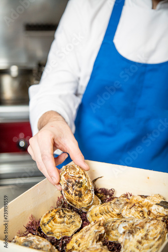 chef prepara ostra cruda ennrestaurante gourmet de lujo