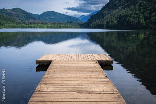 Wooden pier on lake site facing a beautiful mountain on a summer morning