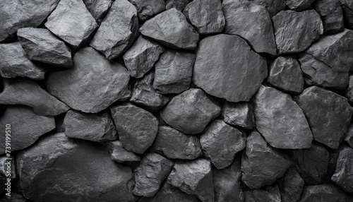 Close-up detailed of textured black rocks or gravel  uniformly spread. Highlights natural patterns and shapes