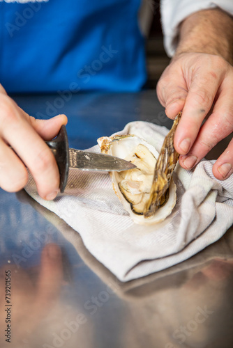 Chef prepara y aliña ostra cruda deliciosa gourmet en restaurante de lujo photo