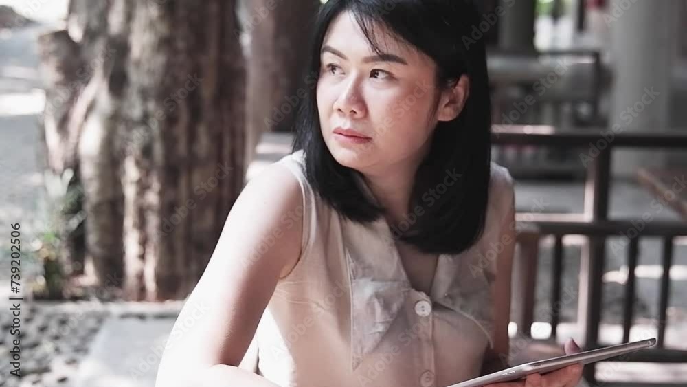 Smiling Asian woman is working and online shopping for successful with tablet. Technology with businesswoman