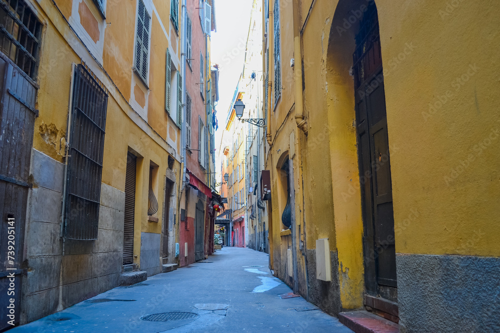 Fototapeta premium Nice, France, 02/13/2024: The architecture of the old town in Nice boasts a blend of Italian style with French motifs, characterized by colorful houses and narrow streets.