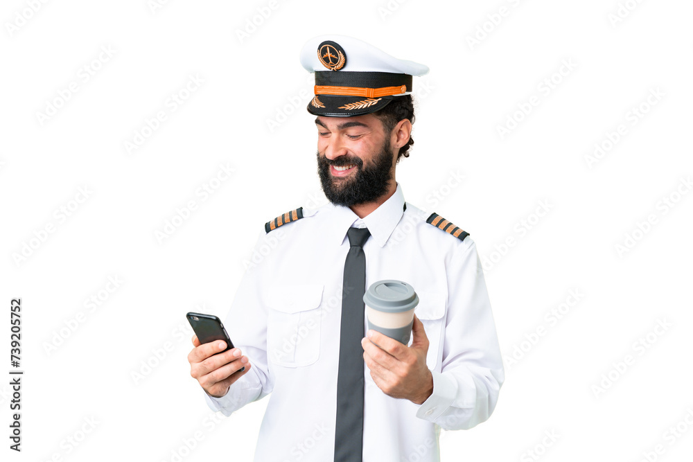 Airplane caucasian pilot man over isolated chroma key background holding coffee to take away and a mobile Airplane caucasian pilot man over isolated chroma key background holding coffee to take away and a mobile