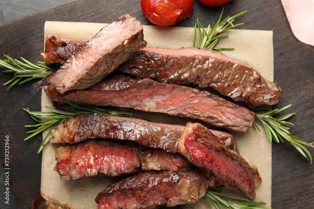 Delicious grilled beef with tomatoes and rosemary on table, top view
