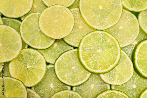 Many juicy lime slices as background, top view