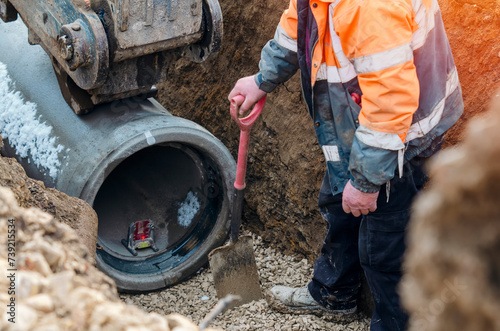 Groundworkers laying new concrete pipes during deep drainage work on the new housing project photo