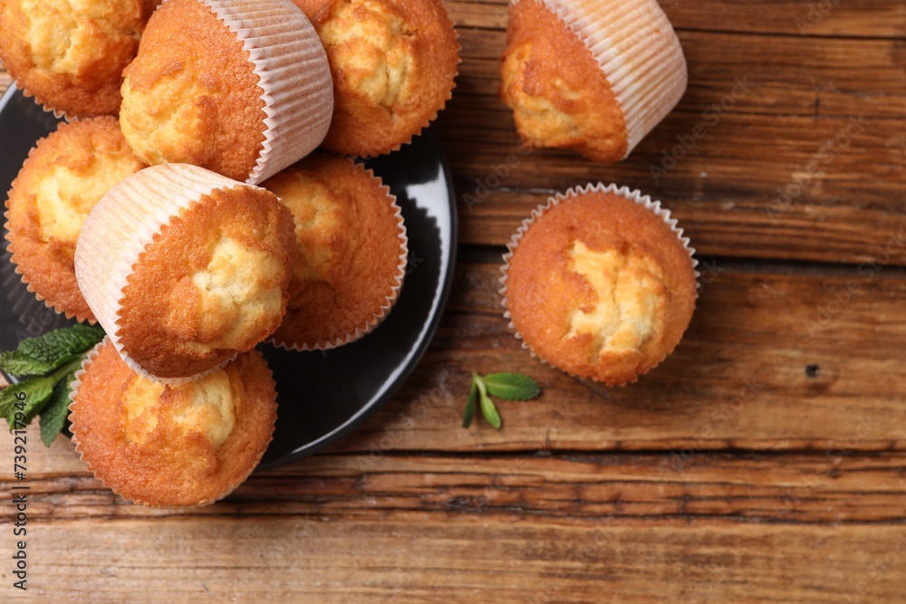 Delicious sweet muffins on wooden table, flat lay. Space for text Delicious sweet muffins on wooden table, flat lay. Space for text