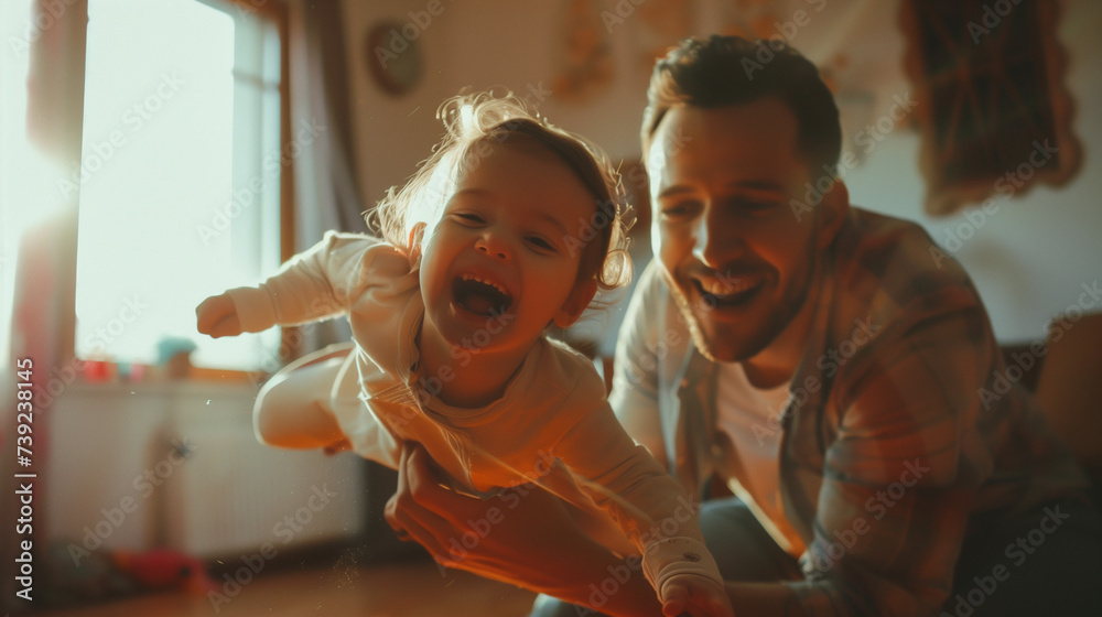 Obraz premium Father playing airplane with his toddler daughter, both smiling joyfully