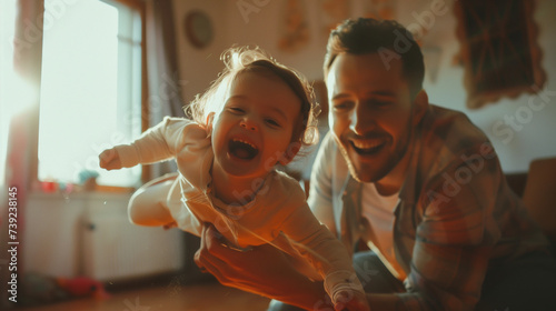 Father playing airplane with his toddler daughter  both smiling joyfully
