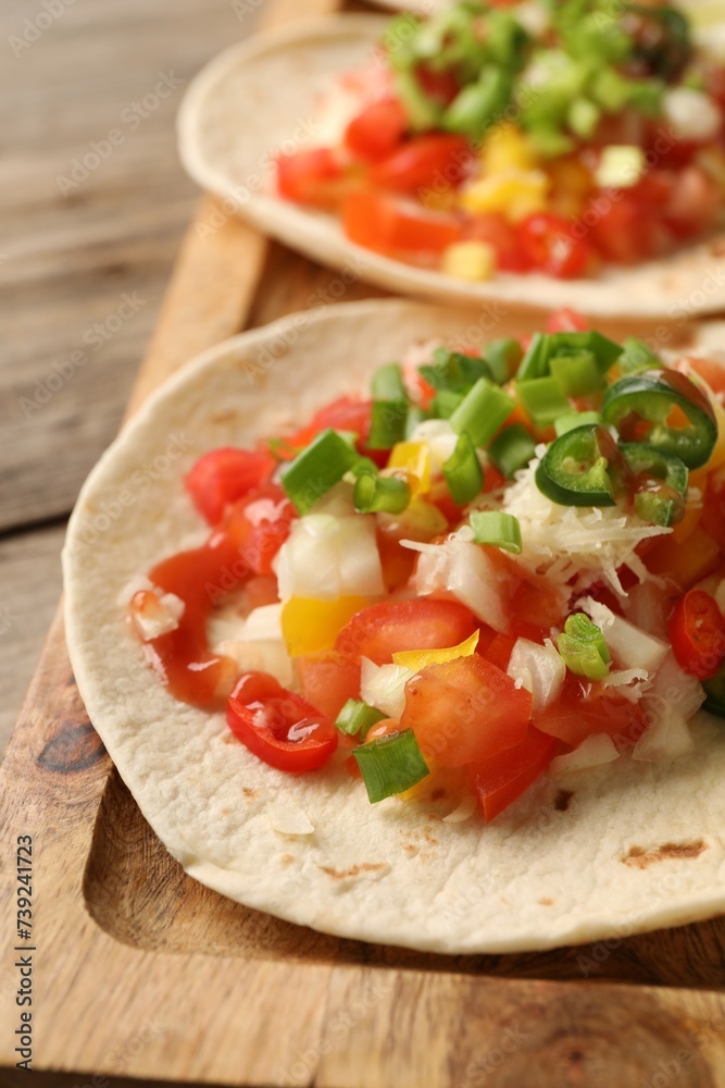 Delicious tacos with vegetables, green onion, lime and ketchup on wooden table, closeup Delicious tacos with vegetables, green onion, lime and ketchup on wooden table, closeup