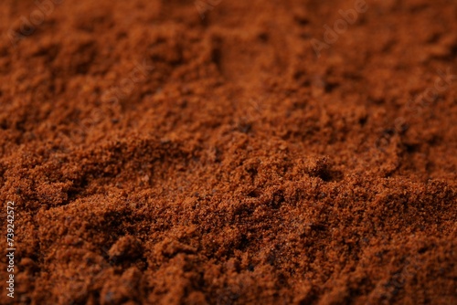 Heap of nutmeg powder as background, closeup