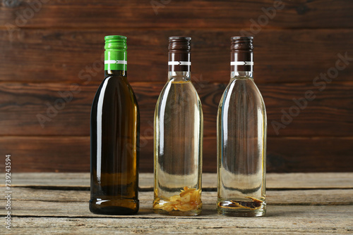 Vegetable fats. Different cooking oils in glass bottles on wooden table