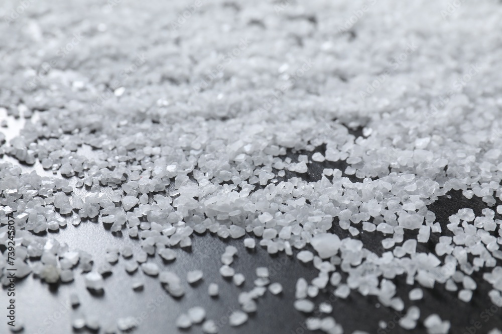 Scattered natural salt on black table, closeup Scattered natural salt on black table, closeup