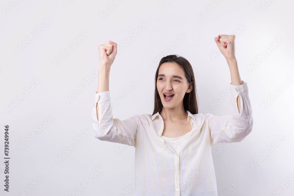 Happy young caucasian female wearing a white shirt clenched fist up for joy. Success and happiness of the work. Successful person, victory! Happy young caucasian female wearing a white shirt clenched fist up for joy. Success and happiness of the work. Successful person, victory!