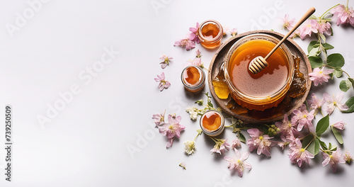 Jar with fresh organic honey and flowers at white background, top view. Banner