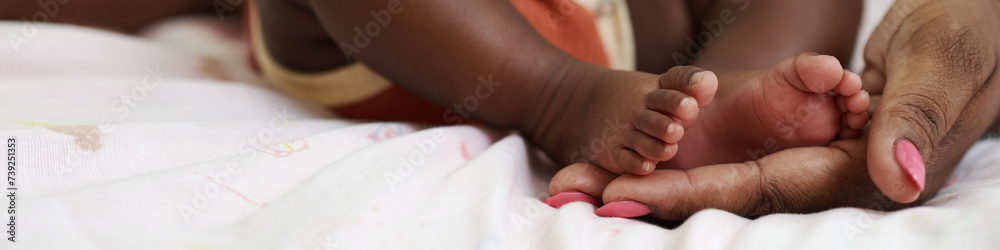 Header with mother touching feet of newborn baby Header with mother touching feet of newborn baby