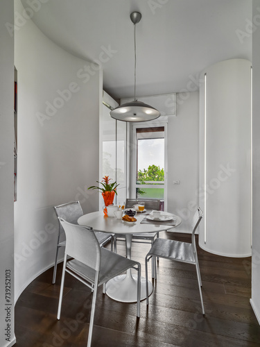 interior view of a modern dining room in the foreground the round table with its chairs (ID: 739252103)