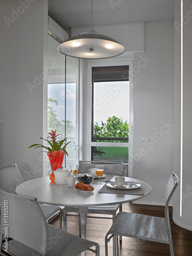 interior view of a modern dining room in the foreground the round table with its chairs (ID: 739252151)