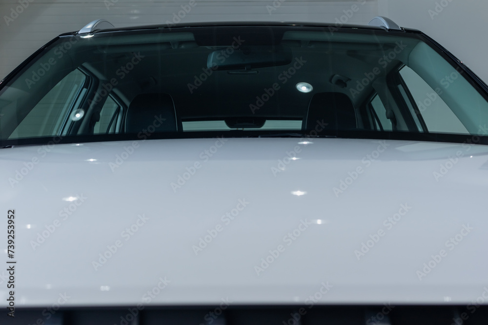 White front hood of modern car against background of windshield close-up