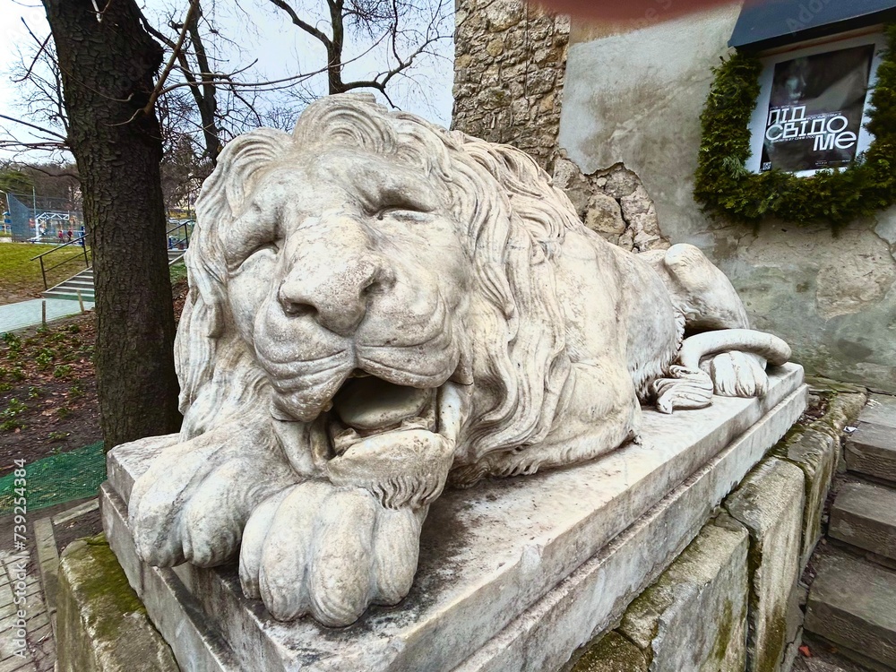 A beautiful old stone sleeping lion decorates the porch of a building, Lviv, Ukraine A beautiful old stone sleeping lion decorates the porch of a building, Lviv, Ukraine