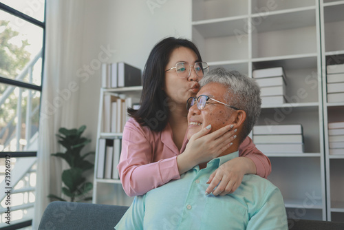 A father and daughter sat in the living room happily spending time together after not seeing each other for a while, A warm family is in the house, Elderly father and teenage daughter