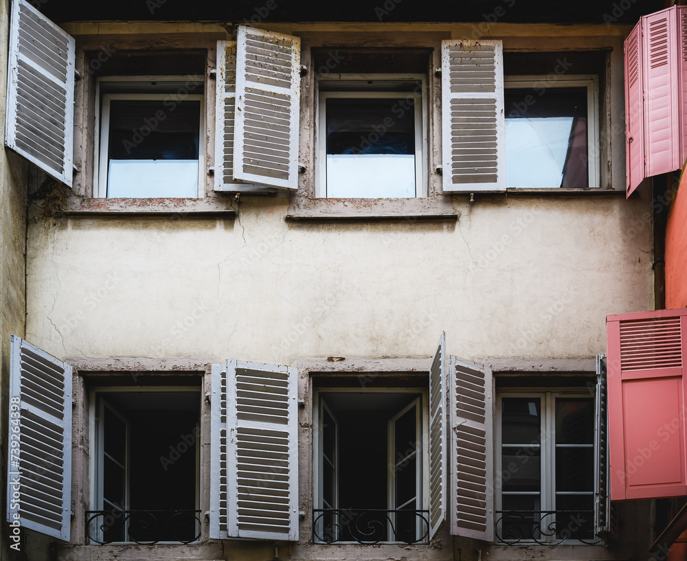 Windows with shutters of an old abandoned house in Colmar, France