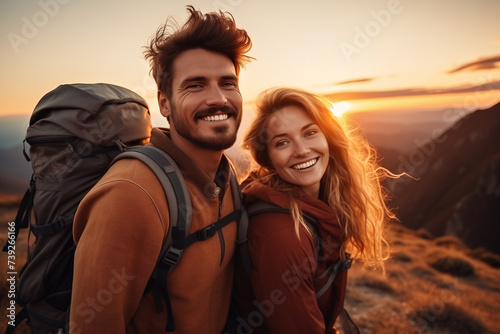Happy young couple with backpacks standing on top of a mountain © kazakova0684