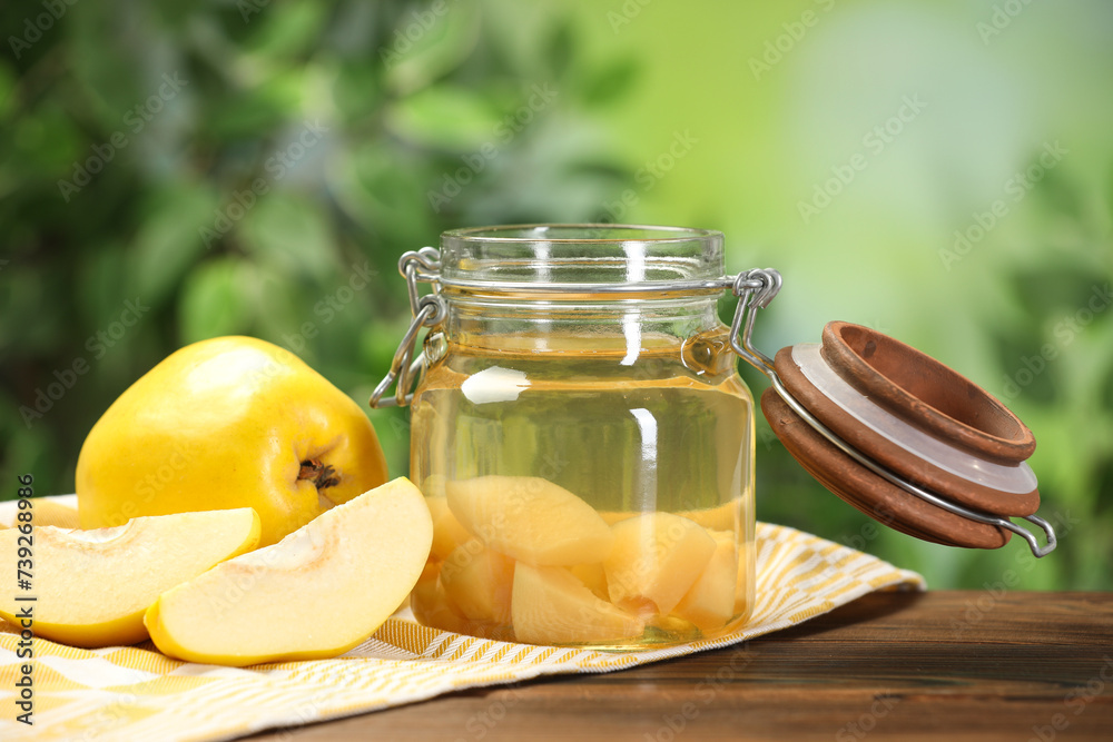 Delicious quince drink and fresh fruits on wooden table against blurred background Delicious quince drink and fresh fruits on wooden table against blurred background